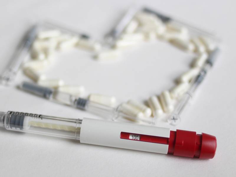 Een spuit en medicatie in een hartvorm