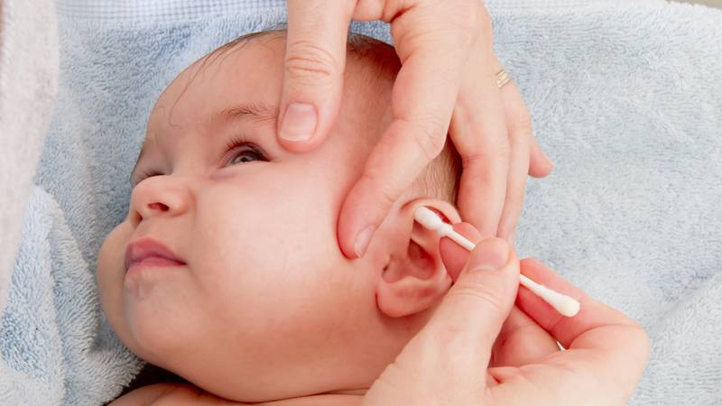 Moeder oren van baby aan het schoonmaken