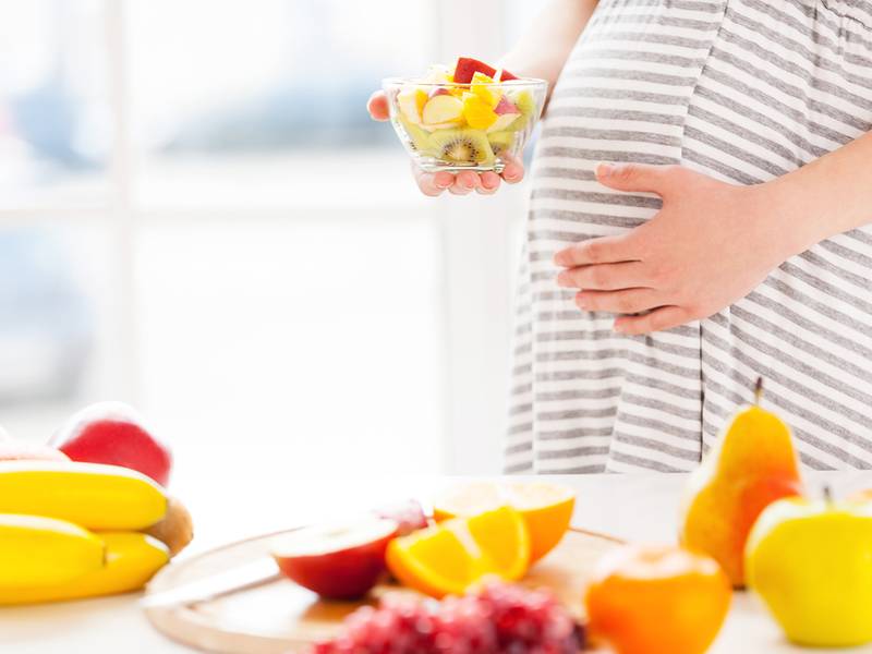 Zwangere vrouw met veel fruit